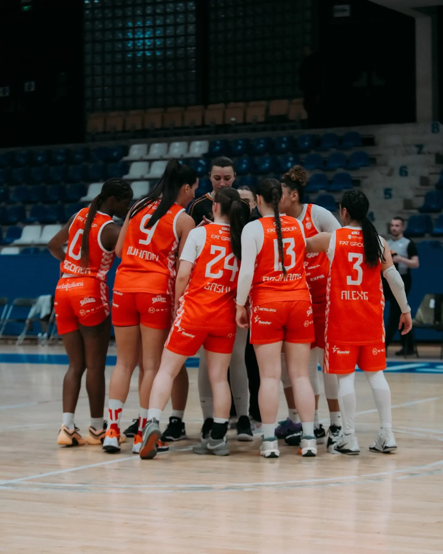 Lojtaret e KBF Bashkimit me fanellat portokalli të mbledhura në rreth në parket