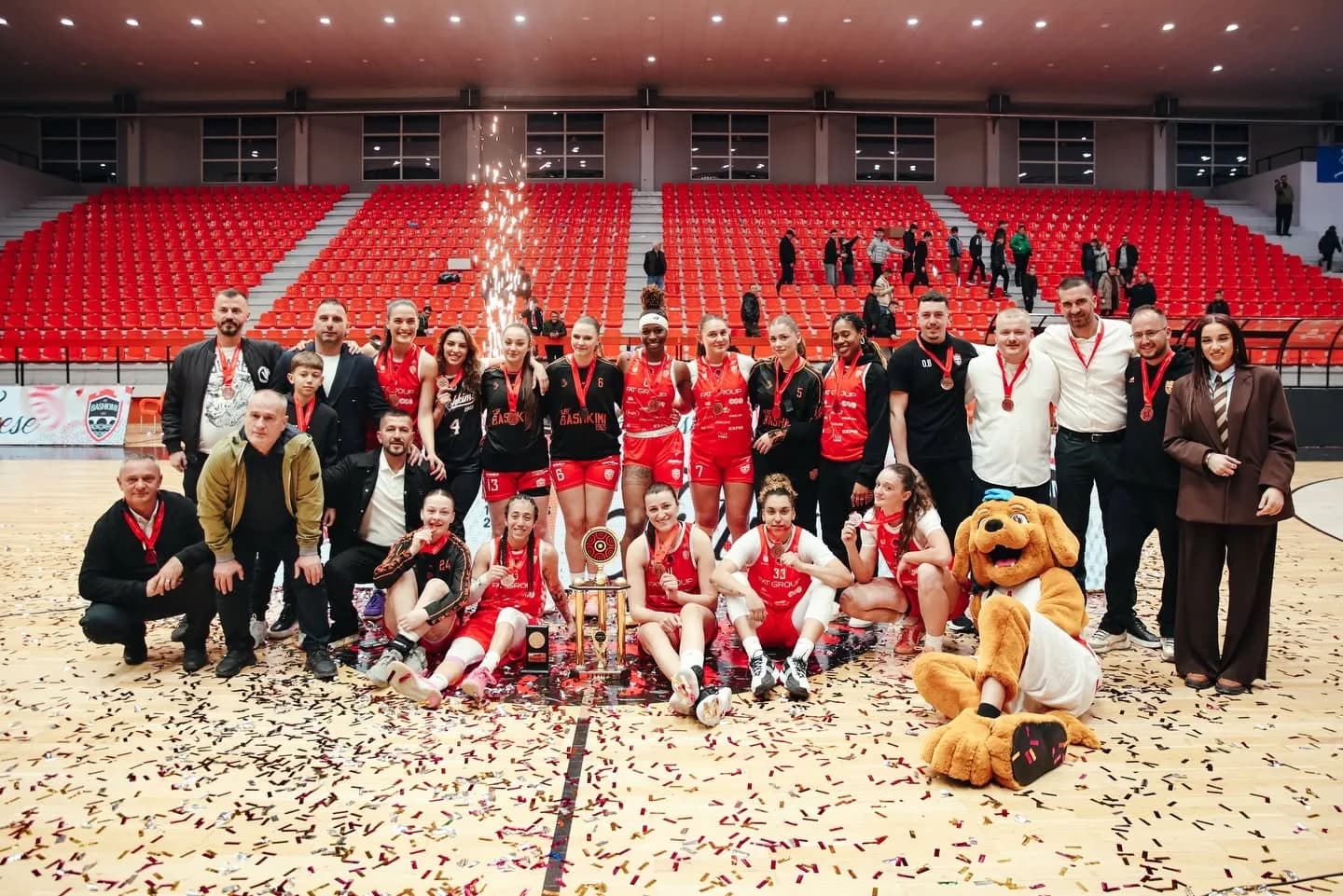 Ekipi dhe stafi i KBF Bashkimit me medalje dhe trofeun në parket, mes konfetit